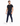 A man in a fitted black t-shirt and navy pants with a chain detail, walking in white sneakers.