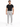 A man stands confidently in a fitted black t-shirt and light gray pants, paired with white sneakers.