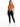 A woman stands confidently in a cropped, rust-colored top tied at the waist, paired with black leggings and white sne...