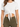 A cropped white top with short sleeves, featuring a front knot detail, paired with olive green high-waisted bottoms.