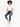 A model with curly hair sits on a stool, wearing a cropped white top and blue jeans with rolled cuffs.