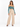 A woman poses in a fitted teal top with long sleeves and high-waisted beige trousers, showcasing a stylish look.