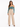 A woman stands confidently in a teal long-sleeve top paired with beige high-waisted wide-leg pants.