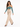 A woman walks confidently in a teal off-the-shoulder top paired with beige high-waisted trousers and black heels.