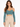 A woman models a teal cropped top with off-the-shoulder sleeves, paired with high-waisted beige trousers.
