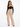 A woman poses in a black off-the-shoulder top and beige high-waisted wide-leg pants, showcasing a stylish look.