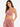 A woman models a sleeveless, cowl-neck crop top in soft pink fabric, paired with matching relaxed-fit pants.