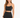 A model wearing a fitted black skirt with a high waist and a matching cropped top, showcasing a sleek silhouette.