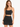 A model wearing a fitted black skirt with a high waist and a matching cropped top, showcasing a sleek silhouette.