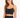 A woman with long hair wears a fitted black crop top with thin straps, showcasing a stylish and casual look.