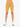 A person wearing mustard-colored ribbed shorts with a crossover waistband, paired with white sneakers.