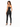A woman stands with her back to the camera, wearing a fitted black crop top and matching high-waisted pants.