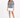 A model poses in a gray tie-dye tee featuring playful graphics, paired with a white mini skirt and black heels.