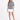 A model poses in a gray tie-dye tee featuring playful graphics, paired with a white mini skirt and black heels.