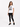 A woman stands wearing a white graphic tee with a zebra print design, paired with black leggings and sneakers.