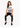 A woman sits on a stool wearing a white graphic tee with a zebra print design and black skinny jeans.