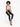 A model with curly hair sits on a stool, wearing a light blue cropped top and black skinny jeans.