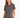 Woman wearing a gray short-sleeve tee with a stylish graphic design on the front, paired with a white skirt.
