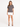 Gray short-sleeve tee with "Brooklyn" graphic, paired with a white mini skirt and black strappy heels.