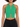 A model wearing a fitted green ribbed crop top with a halter neck and keyhole cutout detail.