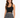 A woman with long, wavy hair wears a fitted black ribbed crop top paired with a patterned black and white skirt.