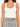 A fitted white ribbed crop top with wide straps, paired with a black and white patterned skirt.