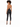 A model with curly hair wears a backless top and fitted black pants, showcasing a stylish outfit.