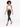 A model walks confidently in a light-colored halter top paired with black skinny jeans and strappy heels.