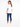 A woman with long hair wearing a white tee and blue jeans, standing with her back to the camera.