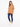A model wearing a relaxed brown tee paired with distressed blue jeans and white sneakers, standing against a plain ba...