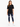 A woman stands confidently in a black oversized tee paired with distressed blue jeans and white sneakers.