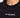 Close-up of a woman wearing a black tee featuring white embroidered text on the chest.