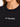 Close-up of a woman wearing a black tee featuring white embroidered text on the chest.
