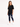 A woman stands in a black oversized tee paired with distressed skinny jeans and white sneakers.