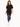 A woman walks confidently in a black oversized tee paired with distressed skinny jeans and white sneakers.