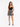 A model poses in a fitted black crop top and a flared skirt with a monochrome animal print design.