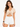 A model wearing a beige cropped top with a V-neck and drawstring detail, paired with white denim shorts.