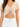 A cropped beige top with a V-neck and gathered front detail, featuring a tie closure at the waist.