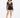 A model poses in a sheer long-sleeve top and high-waisted black shorts, showcasing a stylish, modern look.