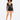 A model poses in a sheer long-sleeve top and high-waisted black shorts, showcasing a stylish, modern look.