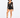 A model poses in a sheer long-sleeve top and high-waisted black shorts, paired with strappy heels.