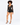 A model poses in a sheer long-sleeve top and high-waisted black shorts, paired with strappy heels.