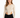 A model wearing a fitted, ribbed long-sleeve bodysuit with cut-out sides, paired with black jeans.