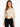 A model wearing a fitted, ribbed long-sleeve bodysuit with cut-out sides, paired with black jeans.