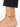 Ankle bracelet featuring black beads and a gold peace symbol charm, worn on a bare foot.