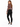 A woman with long hair poses in a fitted brown top and black skinny jeans, showcasing a stylish back cutout.