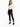 A model poses in a fitted long-sleeve top with a cutout design, paired with black skinny jeans and sneakers.