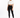 A woman with curly hair stands confidently in black leggings and a cropped white top, paired with stylish boots.