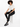 A person with curly hair sits on a white cube, wearing black leggings and a cropped white shirt with stylish sneakers.