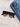 Stylish sunglasses with a black frame and tortoiseshell accents, resting beside folded denim jeans.